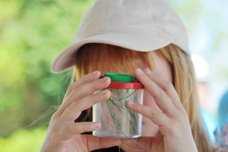 Kind schaut in Lupenglasbecher